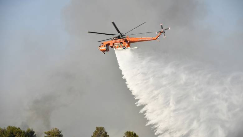 Φωτιά στην Πάτρα: Βίντεο με ελικόπτερο που κάνει ρίψεις νερού δίπλα σε δρόμο που περνούν αυτοκίνητα