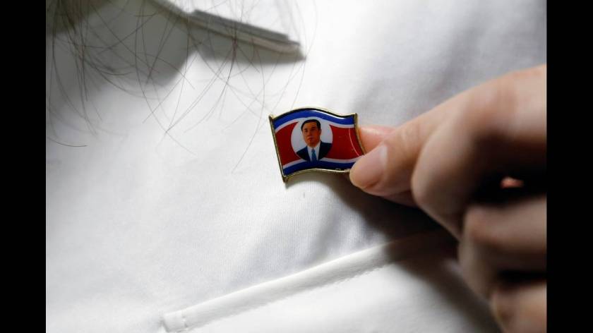 Καρφίτσα με τη σημαία της Βόρειας Κορέας, με τη μορφή του ιδρυτή της Κιμ ιλ Σουνγκ στο κέντρο της.