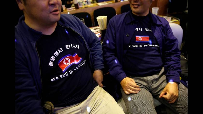 Μπλούζες με τη σημαία της Βόρειας Κορέας φορούν τα μέλη του κλαμπ κατά τη διάρκεια εκδήλωσης.
