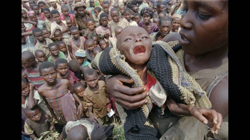 1997, Ζαίρ, Ρουάντα:
Μια νεαρή πρόσφυγας από τη Ρουάντα κρατάει την αδελφή της που πεθαίνει από υποσιτισμό, στην Καλίμα του Ζαίρ. Περπάτησαν ως εδώ από τη Σαμπούντα, όπου πέθαναν οι γονείς τους την περασμένη εβδομάδα. Περίπου 25.000 πρόσφυγες που περπάτη