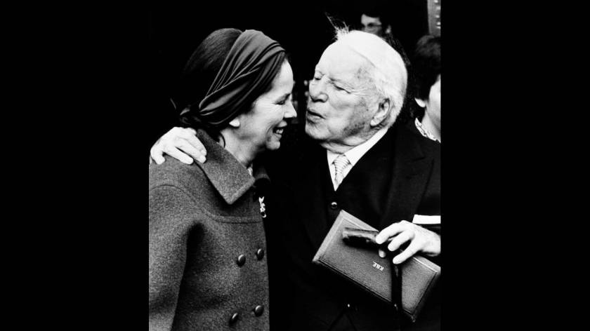 1975
Ο Τσάρλι Τσάπλιν φιλάει τη σύζυγό του, έξω από το παλάτι του Μπάκιγχαμ, στο Λονδίνο. Λίγο νωρίτερα η βασίλισσα Ελισάβετ τον έχει χρίσει ιππότη.