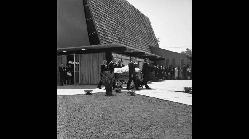 1962, Χόλιγουντ. Το φέρετρο με το άψυχο σώμα της Μέρλιν Μονρόε μεταφέρεται από το περεκκλήσι στο οποίο εψάλη η νεκρώσιμος ακολουθία, στην κρύπτη στην οποία θα ταφεί.