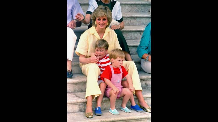 1987, Μαγιόρκα. Η πριγκίπισσα Νταϊάνα με τους γιους της, Χάρι και Ουίλιαμ, στα σκαλιά του παλατιού στη Μαγιόρκα, όπου κάνουν διακοπές, καλεσμένοι τηςισπανικής βασιλικής οικογένειας.